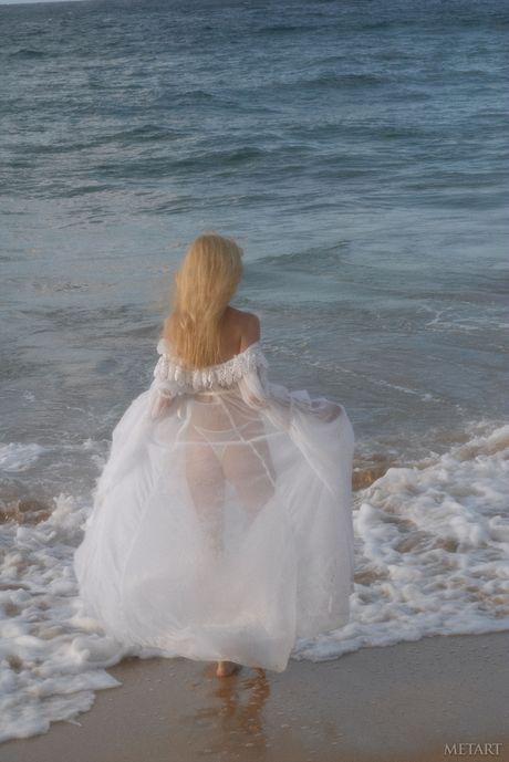 met art: Blonde Russische covergirl Jane A trekt haar jurk uit om naakt te poseren op een klif aan zee